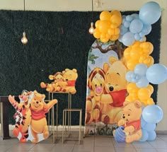 winnie the pooh birthday party decorations with balloons and wall art in front of it