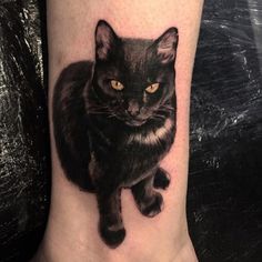 a black cat tattoo on the ankle