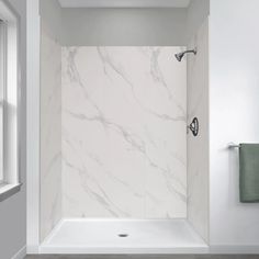 a bathroom with white marble walls and floor