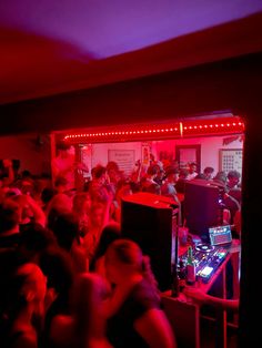 a group of people in a room with red lights