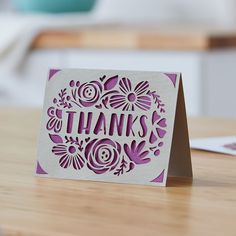 a card with the words thanks on it sitting on a table next to a laptop