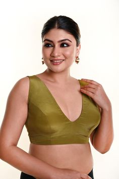 The olive-green sleeveless blouse, crafted in crepe silk with a stylish V-neckline and back closure, is a classic piece that complements any wardrobe. Baluchari Saree, Peach Saree, Green Sleeveless Blouse, Sequin Saree, Orange Saree, Purple Saree, Indo Western Dress, Corporate Wear, Yellow Saree