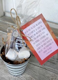 a cup filled with marshmallows next to a card