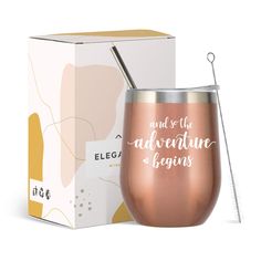 a pink wine cup next to a box with the words adventure begins written on it