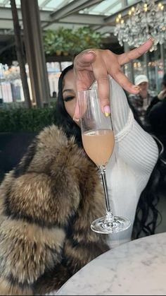 a woman holding up a wine glass in front of her face