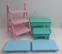 three small children's step stools, one in pink and one in blue