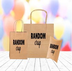 two brown paper bags with random and random logos are sitting on a wooden table in front of balloons