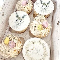 several cupcakes in a cardboard box decorated with bunny ears and other decorative items