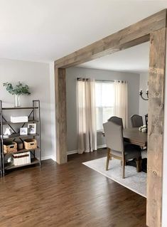 a dining room table and chairs in front of an open door to the living room