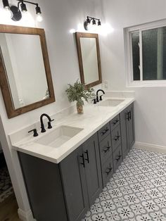 a bathroom with two sinks and mirrors in it