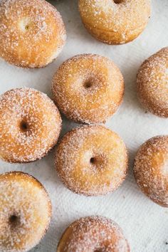 several sugared doughnuts sitting on top of a white towel