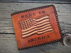 an american flag leather wallet with the words made in america written on it sitting on a wooden surface