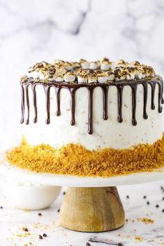 a cake with white frosting and chocolate drizzled on top