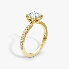 a yellow gold engagement ring with an oval cut diamond on the center and side stones