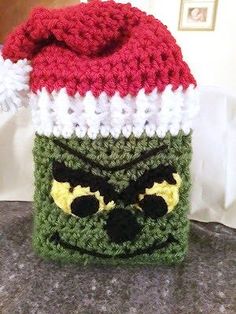 a crocheted green and red hat with eyes