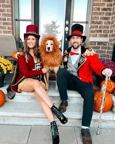 a man and woman dressed up in costumes sitting on steps with their dog wearing a lion costume