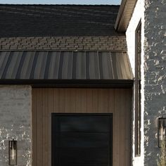 a black garage door in front of a brick building