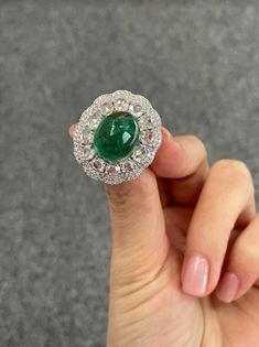 This one-of-a-kind natural emerald ring features an exceptional display of craftsmanship and imaginative design, perfect for those who love the incredible color combination of high-quality green Emerald and diamond. 8.91 carat oval cut vivid green emerald solitaire takes center stage with 2.03 carat of rose cut diamonds and 0.95 carat of round cut diamonds surrounding it. 18K White Gold: 12.06 Grams  Emerald Oval Cab : 8.91 Ctw Diamond Round Rose Cut : 2.03 Ctw Diamond Round : 0.95 Ctw Luxury Green Diamond Ring In Platinum, Green Oval Emerald Ring In Platinum, Oval Hallmarked Emerald Ring In Platinum, Hallmarked Oval Emerald Ring In Platinum, Luxury Oval Emerald Birthstone Ring, Luxury Green Emerald Ring With Rose Cut Diamonds, Luxury Hallmarked Emerald Ring With Diamond, Luxury Green Emerald Ring With Center Stone, Exquisite Green Emerald Platinum Ring