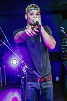 a man standing in front of a microphone on stage