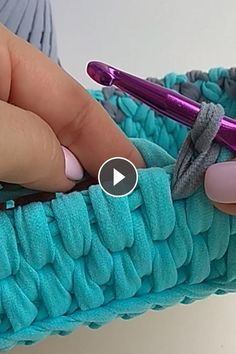 a woman is holding a crochet basket with scissors in it and her thumbnails resting on the handle