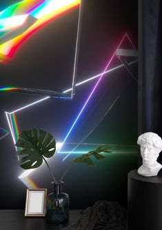 there is a vase with a plant in it next to a rainbow light wallpaper