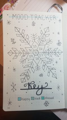 an open notebook with snowflakes and happy new year written on the pages in black ink