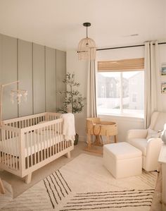 a baby's room with a crib, chair and ottoman