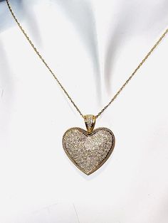 Stunning encrusted diamond heart pendant necklace. The 14K yellow gold twisted rope chain necklace (approx. .3mm) measures approx. 18" in length and closes with a spring ring clasp. The heart shaped pendant has over a hundred bezel set diamonds in white gold (over 1 carat!). The diamonds extend up the bale! The heart is outlined in roped 14k yellow gold border. The heart measures approx. 1" x 1 1/8" (including the bale). Each piece is marked 14K. 5.4 grams total weight Gold Double Heart Diamond Cut Necklace, Gold Diamond-cut Heart Pendant Necklace, Gold Diamond Accented Heart-shaped Necklace, Gold Heart-shaped Diamond Necklace With Accents, Gold Diamond Cut Heart Pendant Necklace, Gold Heart Diamond Necklace With Accents, Gold Jewelry With Pave Setting For Valentine's Day, Gold Diamond Cut Necklace With Heart Pendant, Heart-shaped 14k Gold Jewelry With Pave Setting