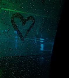 rain drops on the windshield of a car with a heart painted on it's side