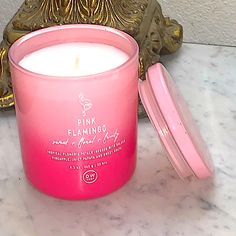 a pink candle sitting on top of a marble counter