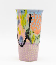 a colorful vase is sitting on a white surface with circles and dots around it, as well as an abstract design