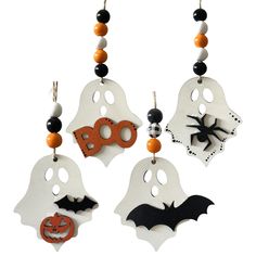 three halloween decorations hanging from strings on a white background with black and orange beads around them