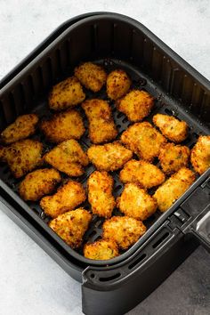 chicken is cooking in an air fryer on the table