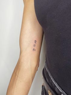 a woman's arm with chinese writing on it and the word love written in cursive letters