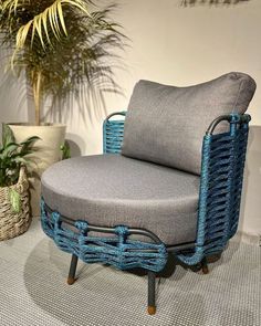 a chair that is sitting on the floor next to a potted plant and some plants