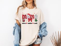 Personalized Christmas Mama Shirt With Kids Name, Comfort Colors Custom Mama Christmas Tee, Coquette Bow Mama Shirt, Christmas Mom Gift  Welcome to the colorful world of PassionTeeApparel. We are sure that you will love our t-shirts designed specifically for everyone. For those looking for modern, cute and comfortable t-shirts, you are at the right place. How to order: - Choose the size of the shirt you want from the drop down menu - Choose the color of the shirt you want from the drop-down menu - Please add your desired design color in the personalization box. Please contact us if you request any additional customization. If you have any problems ordering from us, feel free to message us, we will be happy to assist you. Order details: All of our T-Shirts are made from 100% semi combed Rin Coquette Bow, Christmas Mom, Christmas Gifts For Mom, Christmas Tees, Mama Shirt, Design Color, Mom Gift, Kid Names, Personalized Christmas