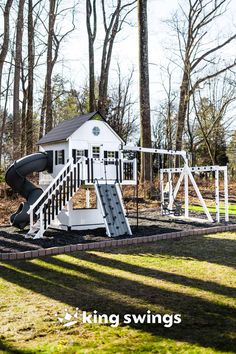 a white house with a slide in the yard