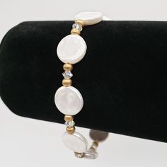 This exquisite freshwater coin pearl clasp bracelet is crafted with flat, round, and lustrous 12mm (approximately 1/2 inch) white pearl beads that are intricately paired with 4mm clear bicone high-quality sparkly clear crystals and delicate matte gold-colored glass spacer beads. The bracelet is secured with a stunning 14K gold-filled lobster clasp and strung on a high-quality, flexible gold-colored wire with wire guards for added security. To ensure the perfect fit, please refer to the listing p Flat Pearl Bracelet, Elegant Handmade Gold-plated Pearl Bracelet, Handmade Adjustable Gold-plated Pearl Bracelet, Adjustable Gold-plated Bracelets With Pearl Charm, Adjustable 14k Gold-filled Pearl Bracelet For Wedding, Adjustable 14k Gold-filled Elegant Pearl Bracelet, Pearl Clasp, Length Measurement, Clasp Bracelet