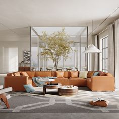 a living room filled with lots of furniture next to a tall glass window covered wall