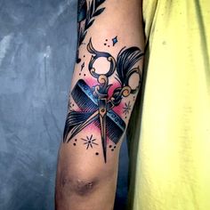 a man's arm with scissors and stars on it