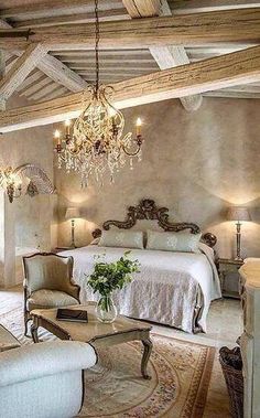 an elegant bedroom with chandelier, bed and couch in the middle of it