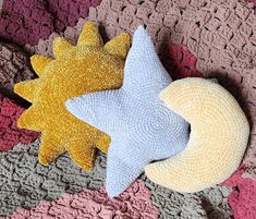 two knitted stars and a moon on a crochet blanket with pink, blue, yellow and grey colors