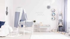 a baby's room is decorated in white and blue tones with pops of color