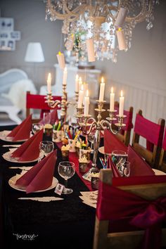 the table is set with red napkins and place settings