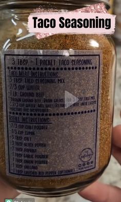 a person holding a jar filled with taco seasoning