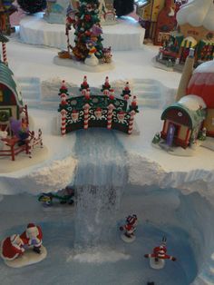 a christmas display with santas and snowmen on the top, water fountain in center