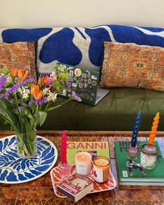 a living room filled with lots of furniture and flowers on top of a coffee table