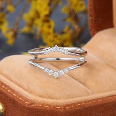 a diamond ring sitting on top of a velvet box