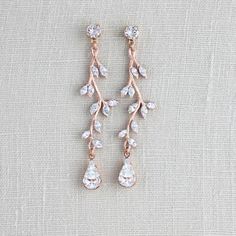 two pairs of gold and crystal earrings on a white cloth with the word love written in it