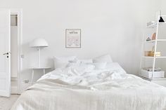 a white bedroom with an unmade bed